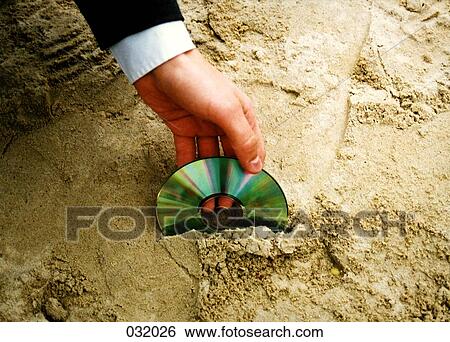A man retrieving a compact disc from sand View Large Photo Image Stock Photograph - A man retrieving a compact disc from sand. Fotosearch