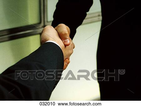 Stock Image - Two people shaking hands. Fotosearch