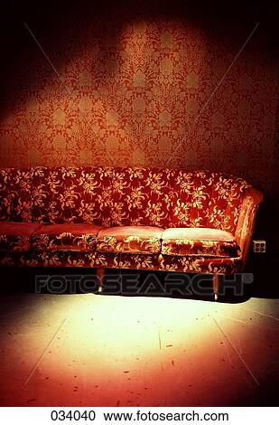 Stock Image - A red sofa in a room with red wallpaper. Fotosearch