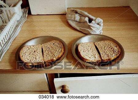Slices of bread on plates on a counter View Large Photo Image Stock Photo - Slices of bread on plates on a counter. Fotosearch