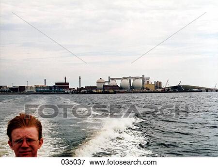 A man at the back of a boat on a lake View Large Photo Image Stock Photo - A man at the back of a boat on a lake. Fotosearch