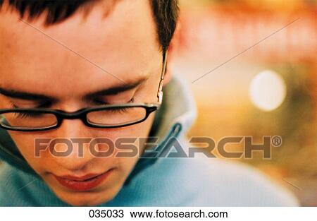 A man with glasses, looking down View Large Photo Image Stock Image - A man with glasses, looking down. Fotosearch