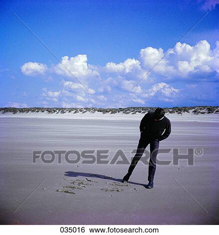 A man writing in the sand with his foot View Large Photo Image Stock Photograph - A man writing in the sand with his foot. Fotosearch