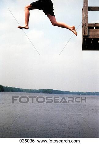 A person jumping off a platform into a lake View Large Photo Image Stock Photograph - A person jumping off a platform into a lake. Fotosearch
