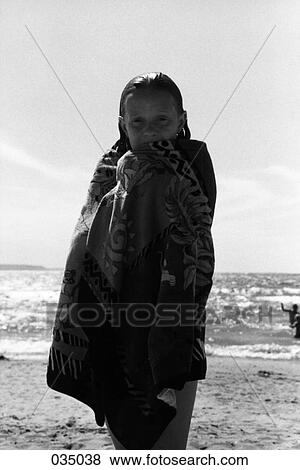 A young girl wrapped in a towel at the beach View Large Photo Image Stock Photo - A young girl wrapped in a towel at the beach. Fotosearch