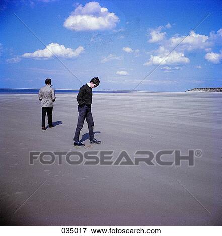 Two people walking on the beach View Large Photo Image Stock Photo - Two people walking on the beach. Fotosearch