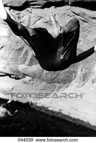 Stock Photo - A man doing a backflip into water. Fotosearch