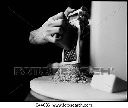 Stock Photograph - A person grating cheese. Fotosearch