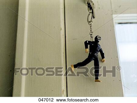 Stock Image - A scuba diver keychain hanging from a door lock. Fotosearch
