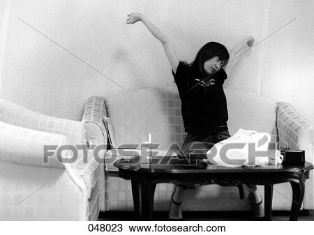 woman stretching her arms on a couch View Large Photo Image Stock Image - woman stretching her arms on a couch. Fotosearch