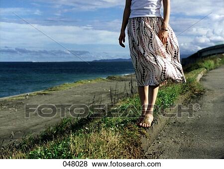 woman wearing a dress standing by the ocean View Large Photo Image Stock Photo - woman wearing a dress standing by the ocean. Fotosearch