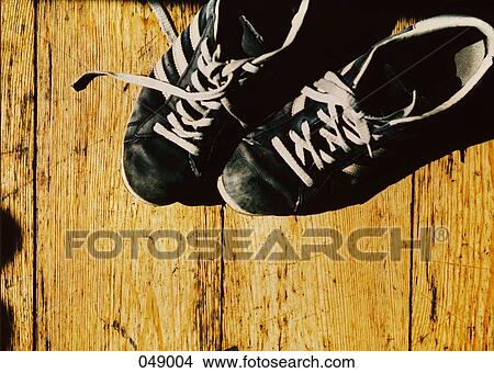 pair of tennis shoes on wooden floor View Large Photo Image Picture - pair of tennis shoes on wooden floor. Fotosearch