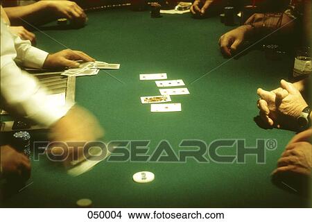 Picture - group of people gambling at a casino blackjack table. Fotosearch