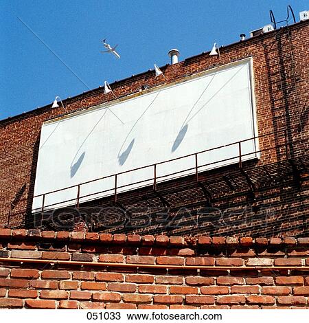 Stock Image - A blank billboard hanging from the side of a brick building. Fotosearch