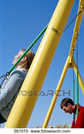 A couple swining at a playground View Large Photo Image Stock Photography - A couple swining at a playground. Fotosearch