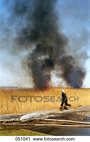 A firefighter running from a blazing field View Large Photo Image Stock Image - A firefighter running from a blazing field. Fotosearch