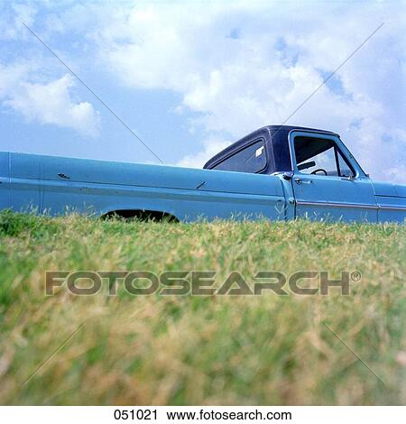 Stock Image - A pick-up truck next to a field. Fotosearch