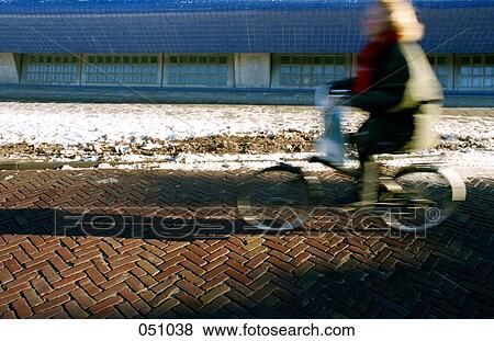 Stock Photo - A woman riding a bicycle. Fotosearch