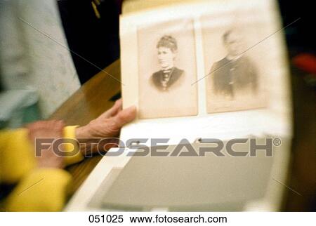 Stock Photography - An eldery woman handles a photo album. Fotosearch
