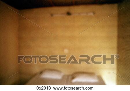 Stock Image - A bed in a wooden room. Fotosearch