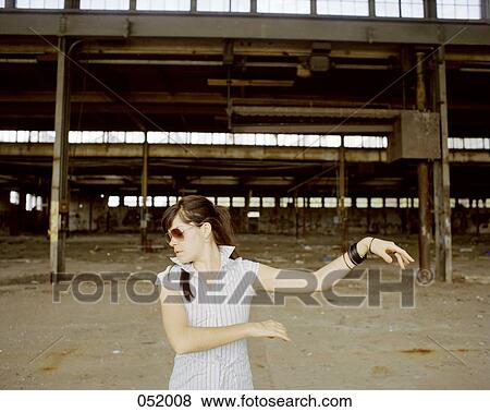 A woman dancing in front of an industrial construction site View Large Photo Image Stock Photo - A woman dancing in front of an industrial construction site. Fotosearch