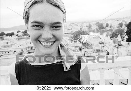 A woman smiling while looking forward above a city View Large Photo Image Stock Photography - A woman smiling while looking forward above a city. Fotosearch