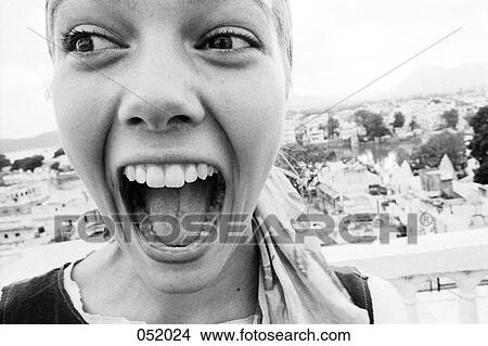 Picture - A woman smiling while looking to her right above a city. Fotosearch