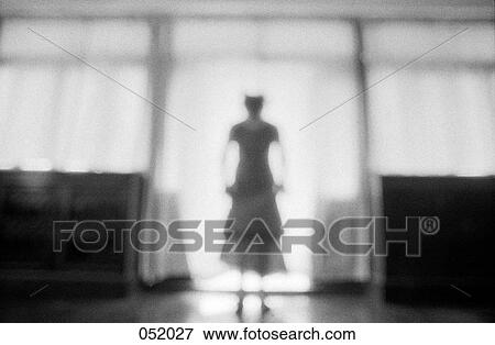 A woman standing in a bright doorway View Large Photo Image Stock Photo - A woman standing in a bright doorway. Fotosearch