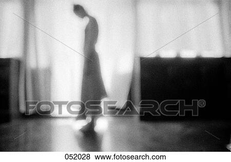 A woman standing in a bright doorway View Large Photo Image Stock Photo - A woman standing in a bright doorway. Fotosearch
