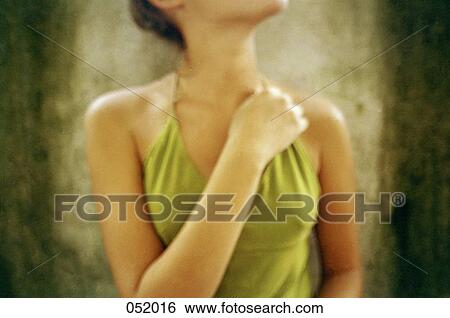 Stock Photograph - A young woman crossing an arm across her chest. Fotosearch