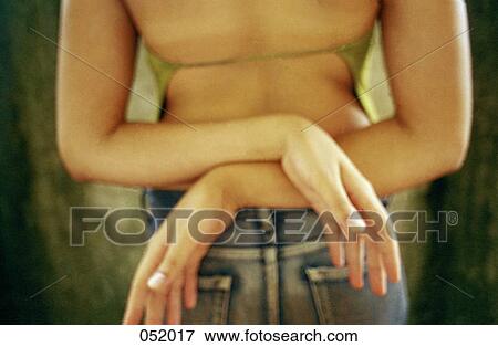 Stock Photo - A young woman crossing her arms behind her back. Fotosearch