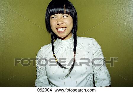 A young woman looking to her right, grimacing View Large Photo Image Picture - A young woman looking to her right, grimacing. Fotosearch