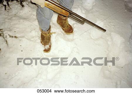 A hunter's legs and rifle in the snow View Large Photo Image Picture - A hunter's legs and rifle in the snow. Fotosearch