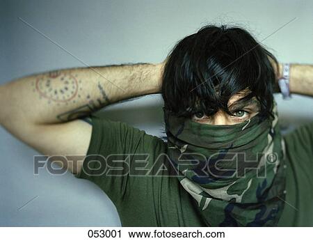 Stock Image - A young man with a bandana covering his face. Fotosearch