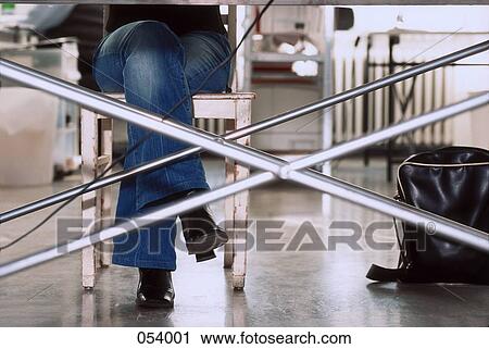 A woman sitting at a desk from below View Large Photo Image Stock Image - A woman sitting at a desk from below. Fotosearch
