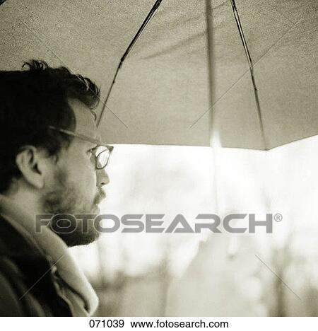 A man holding an umbrella View Large Photo Image Stock Photo - A man holding an umbrella. Fotosearch