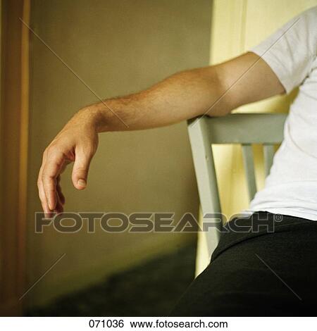 A man sitting on a chair View Large Photo Image Stock Photograph - A man sitting on a chair. Fotosearch