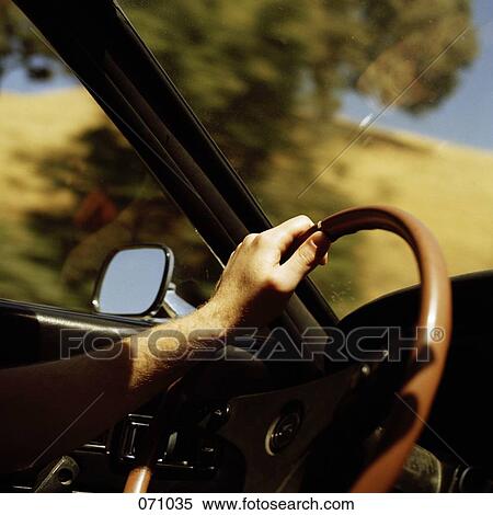 A person's hand on a steering wheel View Large Photo Image Stock Photography - A person's hand on a steering wheel. Fotosearch