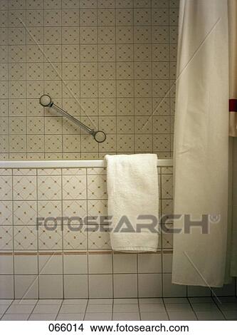 A towel hanging on the side of a bathtub View Large Photo Image Picture - A towel hanging on the side of a bathtub. Fotosearch