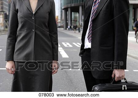 Stock Image - A businessman and a businesswoman standing in a city street. Fotosearch