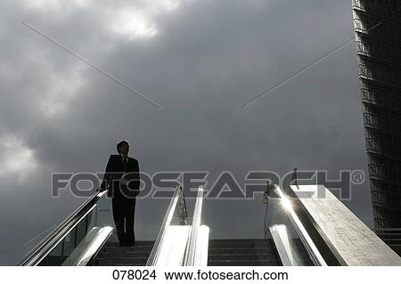 A businessman descending on an escalator View Large Photo Image Picture - A businessman descending on an escalator. Fotosearch