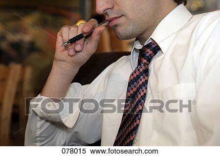 A businessman with a ballpoint pen in his mouth View Large Photo Image Stock Photography - A businessman with a ballpoint pen in his mouth. Fotosearch