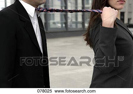 A businesswoman pulling on a businessman's necktie View Large Photo Image Stock Photography - A businesswoman pulling on a businessman's necktie. Fotosearch