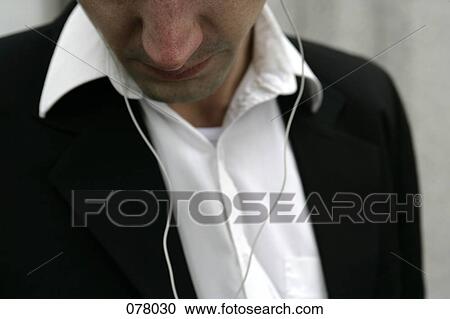 Stock Image - A man listening with earphones. Fotosearch