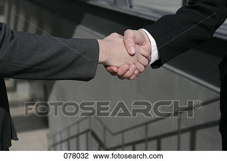 Two businesspeople shaking hands in a stairwell View Large Photo Image Stock Image - Two businesspeople shaking hands in a stairwell. Fotosearch