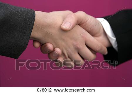 Stock Image - Two businesspeople shaking hands. Fotosearch