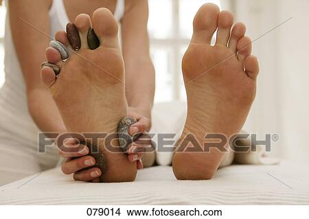 A massage therapist massaging a man's feet View Large Photo Image Picture - A massage therapist massaging a man's feet. Fotosearch