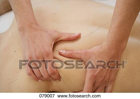 A massage therapist massaging a person's back View Large Photo Image Stock Photo - A massage therapist massaging a person's back . Fotosearch