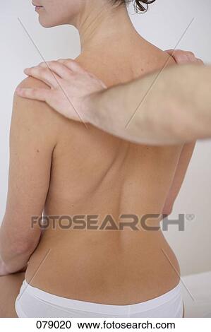 A massage therapist massaging a woman's shoulders View Large Photo Image Stock Image - A massage therapist massaging a woman's shoulders. Fotosearch