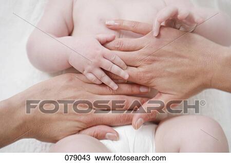 An adult massaging a baby's stomach View Large Photo Image Stock Image - An adult massaging a baby's stomach. Fotosearch